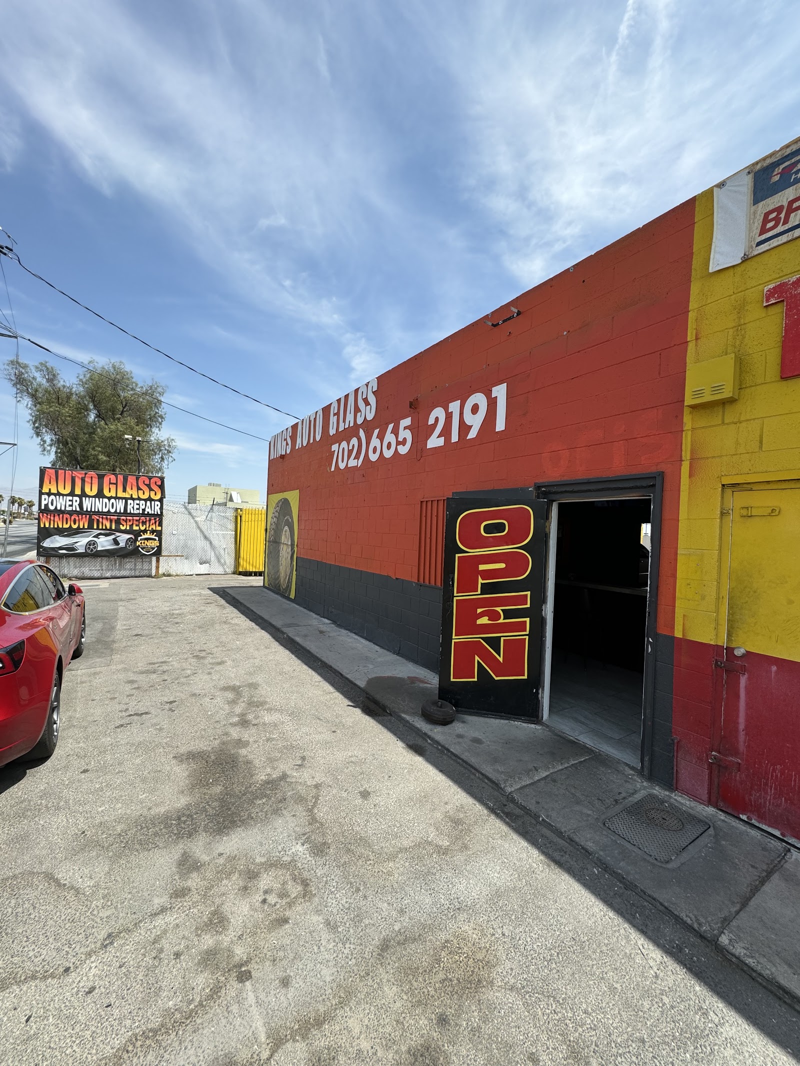 Kings Auto Glass storefront with red and yellow building, OPEN sign and phone number 702-665-2191