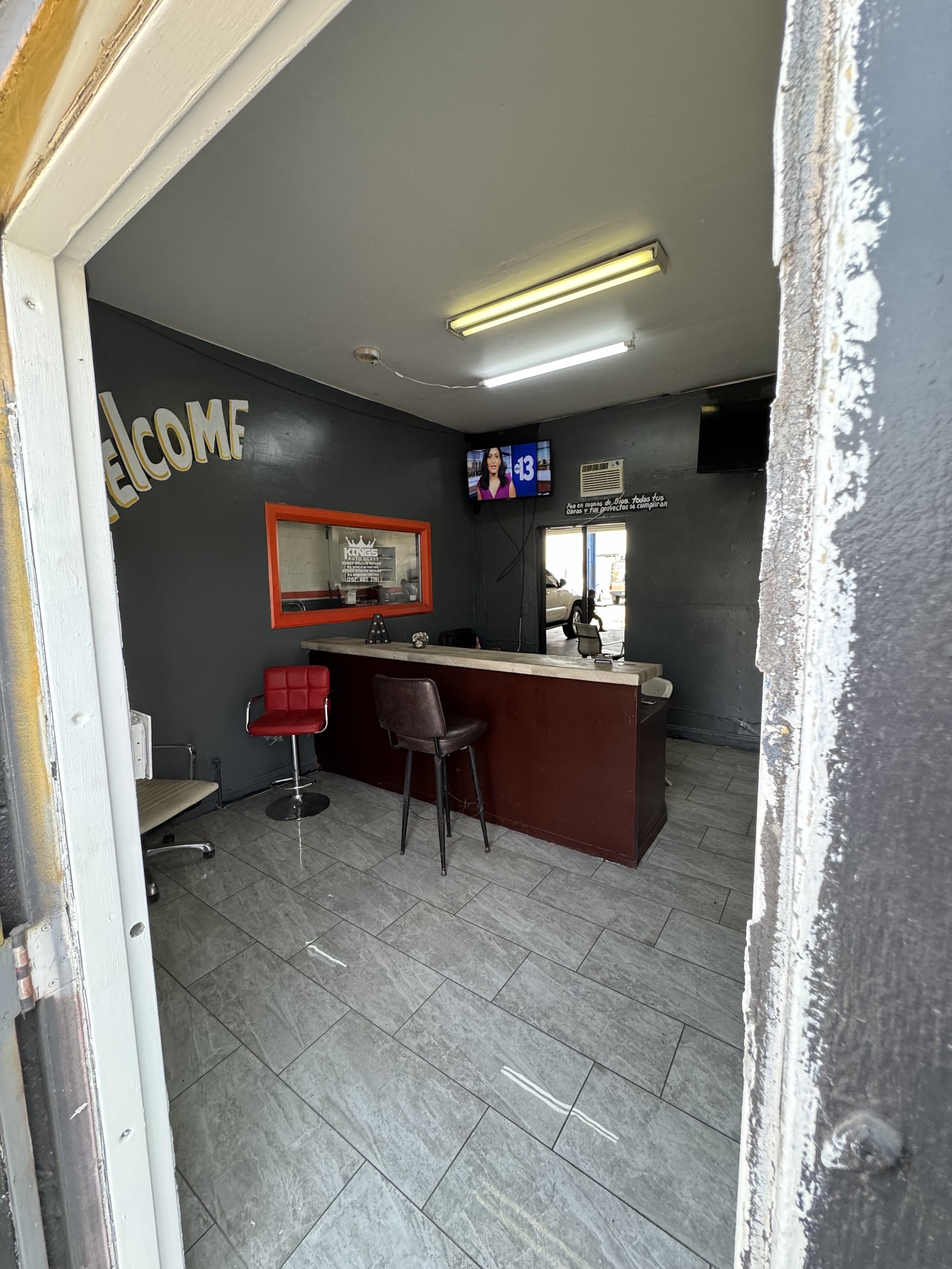 Customer waiting area with Welcome wall, reception counter, TV and seating